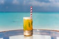 New year and christmas celebration theme cocktail with straw and pine leaves on the glass on the beach