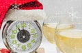 New Year or Christmas composition - an alarm clock in a Santa Claus hat, wine and gifts. New Year and Christmas concept Royalty Free Stock Photo