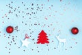 New Year and Christmas composition. Frame from red balls, white stars, chrismas tree, deer and sparkles on pastel blue background Royalty Free Stock Photo