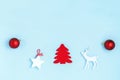 New Year and Christmas composition. Frame from red balls, white stars, chrismas tree, deer and sparkles on pastel blue background Royalty Free Stock Photo