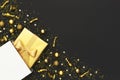 New Year or Christmas composition. Golden gift with ribbon from white paper bag, Christmas balls, confetti stars on black Royalty Free Stock Photo