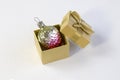 New year and Christmas concept of holiday decorations. Small decorative Christmas strawberry in golden gift box