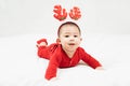 New year and Christmas concept with 5 months old cute newborn baby boy wearing christmas antlers of a deer,red clothes lying on th Royalty Free Stock Photo