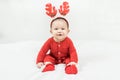 New year and Christmas concept with 5 months old cute newborn baby boy wearing christmas antlers of a deer,red clothes sitting on Royalty Free Stock Photo