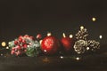 New Year and Christmas decoration, holiday background. Red festive ball bauble, green fir xmas tree and yellow blurred lights. Royalty Free Stock Photo