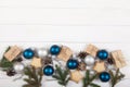 New Year and Christmas decoration made of fir branches, cones, beads, glitter and blue and silver balls on a white background. Royalty Free Stock Photo