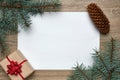 New Year or Christmas festive background. White sheet of paper with copy space, gift box and Christmas tree branches on