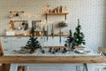 New Year and Christmas 2018. Festive kitchen in Christmas decorations. Candles, spruce branches, wooden stands, table