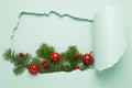 New Year or Christmas layout big hole paper background mint color. Christmas tree branch toys a blue bright background Royalty Free Stock Photo