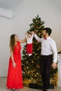 New year and Christmas. Mom and dad hold hands with their little son in the background of the Christmas tree and lift him up Royalty Free Stock Photo