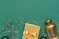 New Year Christmas presents, Christmas balls, champagne glasses, gold confetti stars on green background top view. Flat lay Xmas Royalty Free Stock Photo