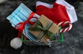 New Year and Christmas shopping. Shopping basket with gift and medical masks Royalty Free Stock Photo