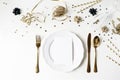 New Year, Christmas styled black and gold table setting with plate, cutlery, confetti stars and champagne wine glass