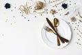 New Year, Christmas styled glamorous black and gold table setting with plate, goldenware, confetti stars and champagne