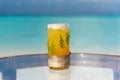 New year and christmas theme tropical cocktail with pine leaves on the glass on the beach Royalty Free Stock Photo