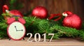 New year 2017,Christmas-tree decoration with a branch of a fir-tree and wooden figures of the coming year, Royalty Free Stock Photo