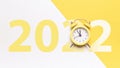 New year clock 2022. Retro style yellow clock in happy Christmas midnight. Countdown to happy xmas on yellow background Royalty Free Stock Photo