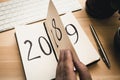 New Year 2019 is coming concept. Female hand flips notepad sheet on wooden table. 2018 is turning, 2019 is opening Royalty Free Stock Photo