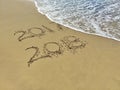 New Year 2018 is coming concept - inscription 2017 and 2018 on a beach sand, the wave is almost covering the digits 7 Royalty Free Stock Photo