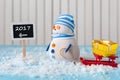 New Year 2017 is coming concept. Snowman with red sled stand near written on direction sign. Royalty Free Stock Photo