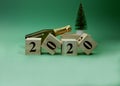 New Year composition with bottle champagne and decorative new year tree. Wooden cube block building the word 2020 Royalty Free Stock Photo