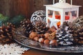 New Year composition: burning lantern, pine cones and Christmas tree decorations.
