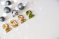 New Year composition silver balls toys and golden numbers 2022 on a white snowy background. Flat lay, top view, copy space Royalty Free Stock Photo