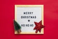 New Year composition of star, tree, white felt board with text Merry Christmas, ho ho ho on red background Holiday card Xmas Royalty Free Stock Photo