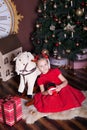 New Year 2020! The concept of Christmas, holidays and childhood. happy little girl in a red dress sits with a wooden nutcracker to Royalty Free Stock Photo