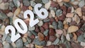 New year concept, white 2026 numbers on wet multi-colored stone background Royalty Free Stock Photo