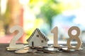 2018 New year concepts,Number two, one, eight, put on coins,Model house replaced by zero.All laid on wooden floor,Light from Royalty Free Stock Photo