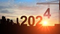 2024. New Year 2024. Construction crane sets numbers for New Year 2024, Silhouette of team works as a to prepare to welcome new