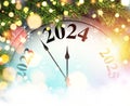 New Year 2024 countdown clock with golden blurred lights and green fir branches