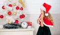 New year countdown. Last minute new years eve plans that are actually lot of fun. Girl kid santa hat costume with clock Royalty Free Stock Photo