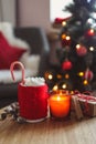 New Year cup with marshmallows, candle and gift on the table on a festive background. Christmas mood Royalty Free Stock Photo