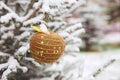 New year decoration Golden Apple hanging on a snow-covered branch of a spruce covered with snow, against the background of a Royalty Free Stock Photo