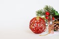 New year decorations: a ball of wire, a Christmas lantern, branches of a holly. White background imitating fresh snow. Free space Royalty Free Stock Photo