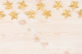 New Year decorations, gold stars on soft beige wooden background. Royalty Free Stock Photo