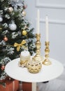 New Year decorations on the table, candles in gold candlesticks, a box