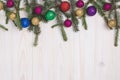 New year decorations on white wooden board, holiday background with fir branch and festive shiny balls. Postcard with Christmas