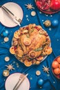 New year dinner table. Roasted Christmas chicken with orange slices, cranberries, garlic, festive decoration, candles, tangerine, Royalty Free Stock Photo