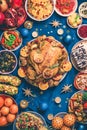 New year dinner table. Roasted Christmas chicken with orange slices, cranberries, garlic, festive decoration, candles Royalty Free Stock Photo