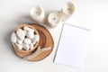 New Year empty notebook list with a bowl of white pebble and boho rustic decorations on a white table. Mockup with copy space for