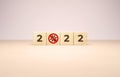 New year 2022 and the end of covid pandemic concept in wooden cubes. Numbers and forbidden sign on coronavirus illustration on a