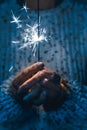 New year eve and christmas celebration concept with close up of hands holding firework sparkler - blue cold tones - emotions and Royalty Free Stock Photo