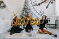 New Year Eve party. Celebrating of New Year. Three beautiful young girls with golden baloons 2020 celebrating new year. Young