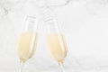 New Year festive background with bright fizz champagne in two glasses in motion of clang glasses together on soft light white.