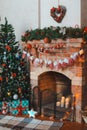 New year festive interior. Christmas tree decorated by the fireplace Royalty Free Stock Photo