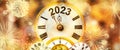 New Year with fireworks and clock counting down to midnight with defocused golden background