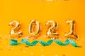 New year 2021 foil balloons on a yellow background. Green measuring tape on yellow background Royalty Free Stock Photo
